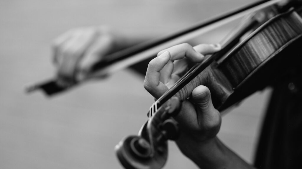 grayscale photo of person playing violin